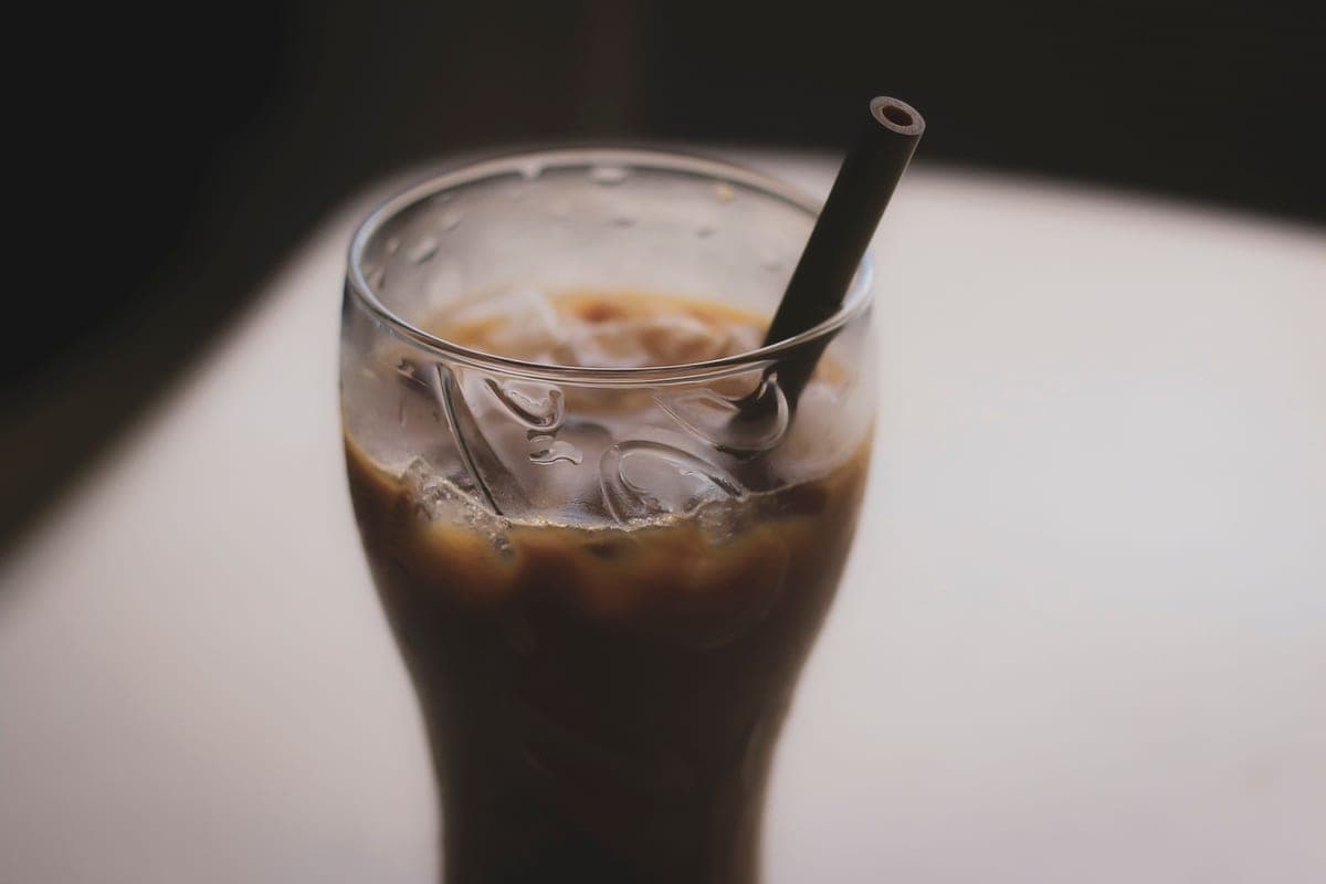 A glass of iced coffee with a straw, close up