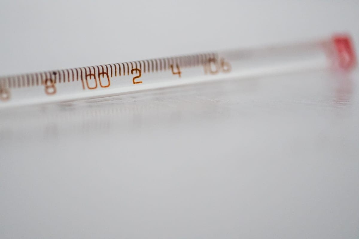 A glass thermometer on a white surface, close up