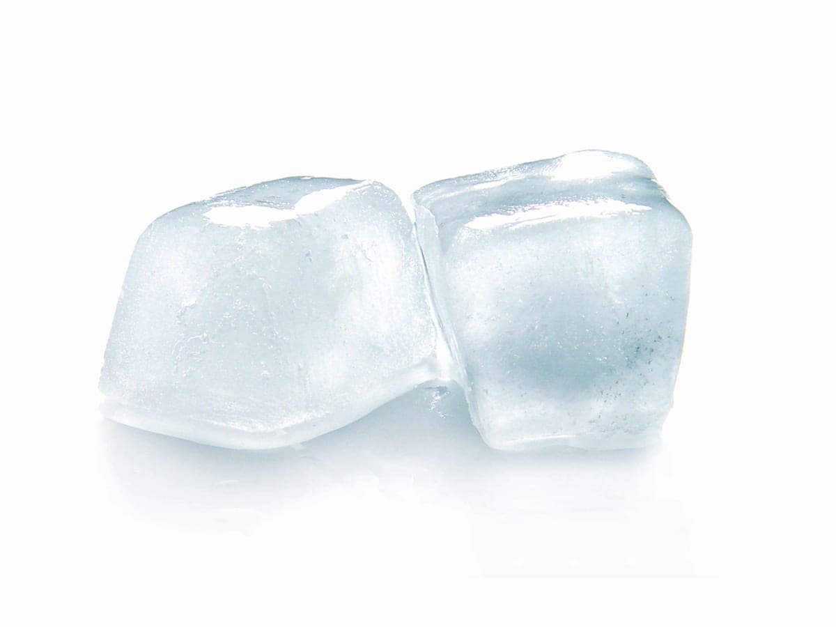 Illustrative stock photo: two ice cubes with melting edges on a white reflective surface