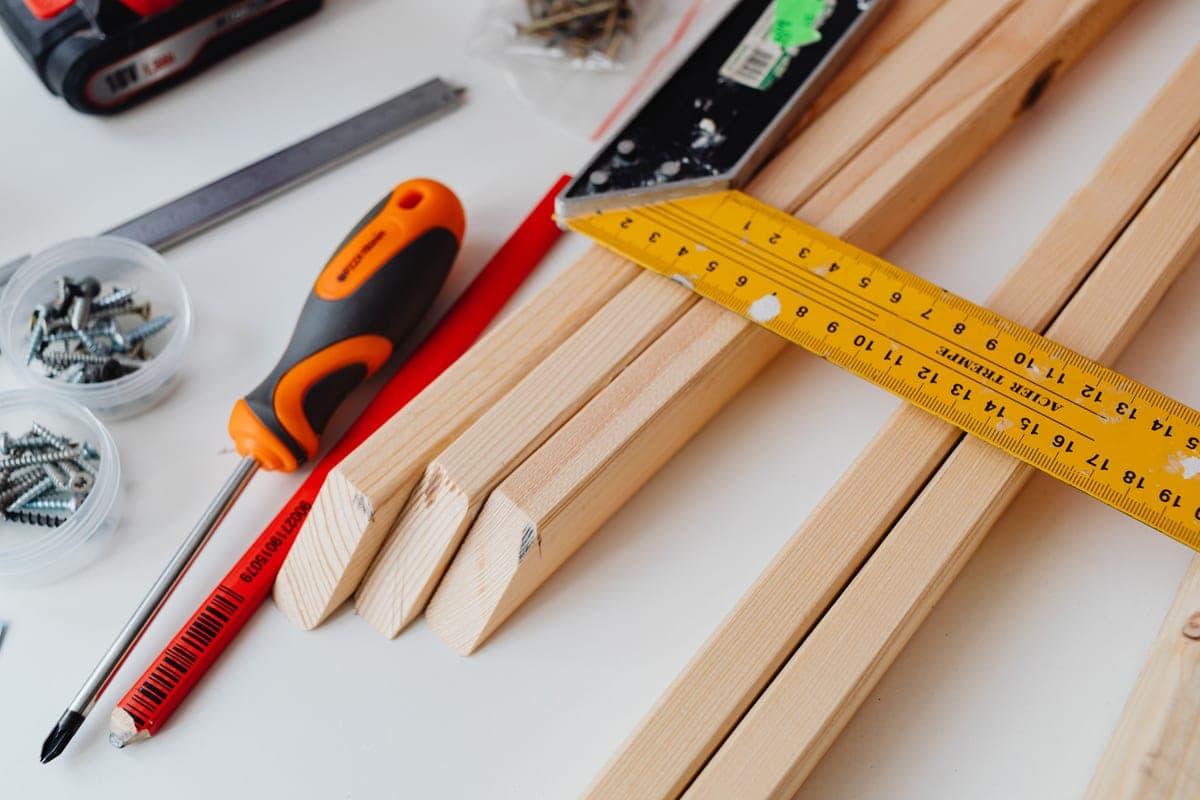 Illustrative stock photo: screws, a screwdriver and a ruler on a woodworking table